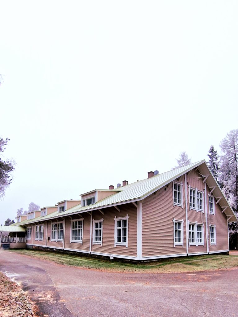 Puinen rakennus kuvattuna pilvisessä säässä. Talo on väriltään vaaleanpunainen ja siinä on kymmeniä ikkunoita.